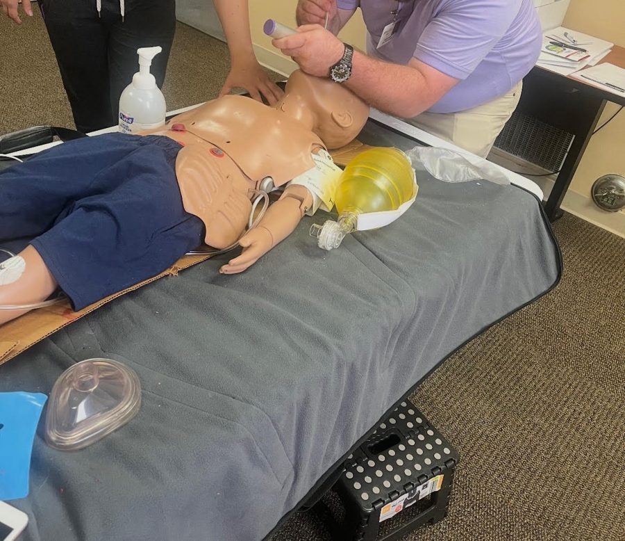 Bag-valve-mask ventilation and AED pads on a CPR training manikin during BLS class